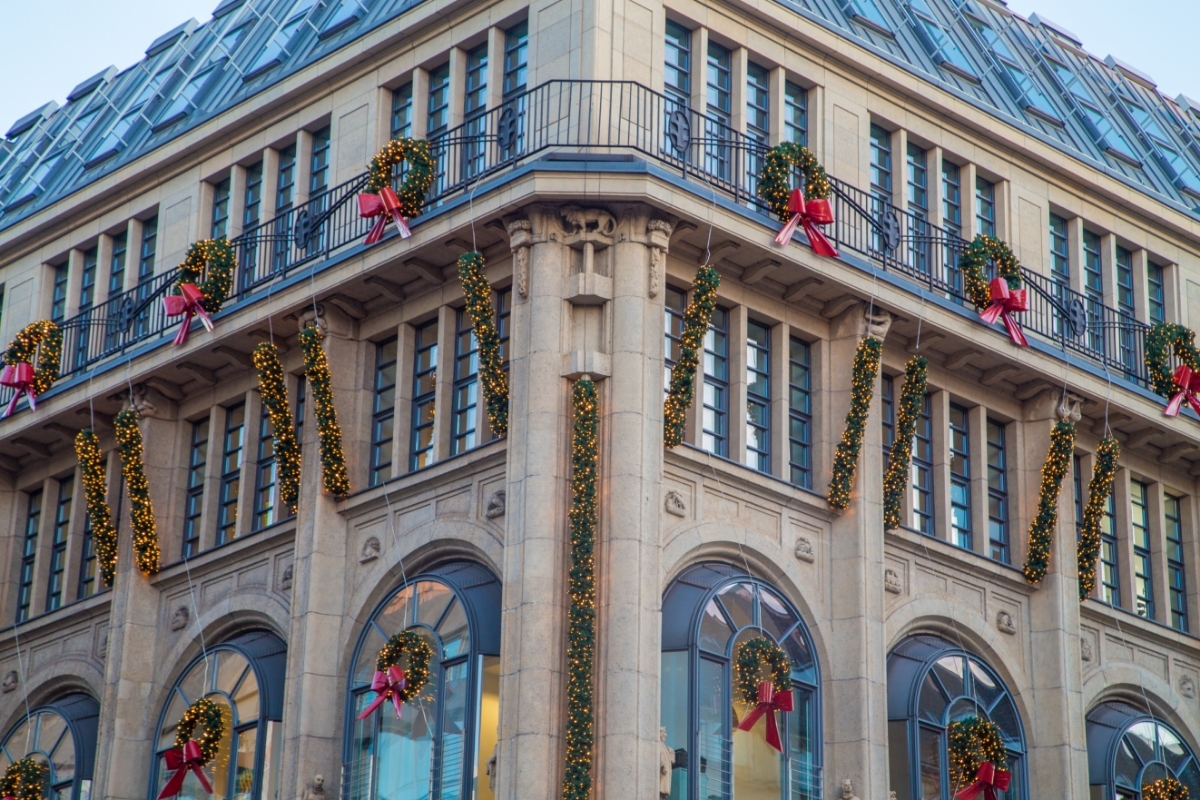 Exterior of a large building decorated with holiday wreaths and garland